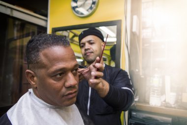 Barber Giving his Client a Haircut, In Barber Shop. clipart
