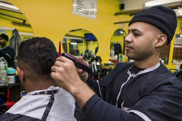 Fryzjer, dając jego klienta fryzura, w sklepie fryzjer. — Zdjęcie stockowe