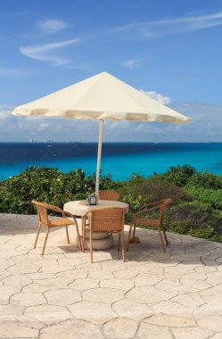 Karayip sahilinde bir şemsiye ile bir tablo