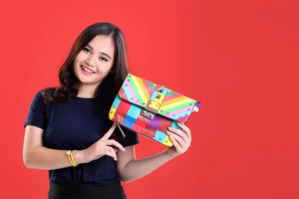 Beautiful fashion girl presenting colorful bag — Stock Photo, Image
