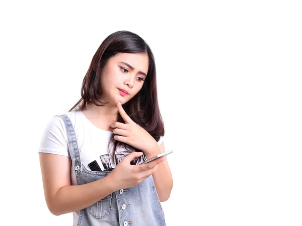 A girl thinking seriously while holding a cellphone — Stock Photo, Image