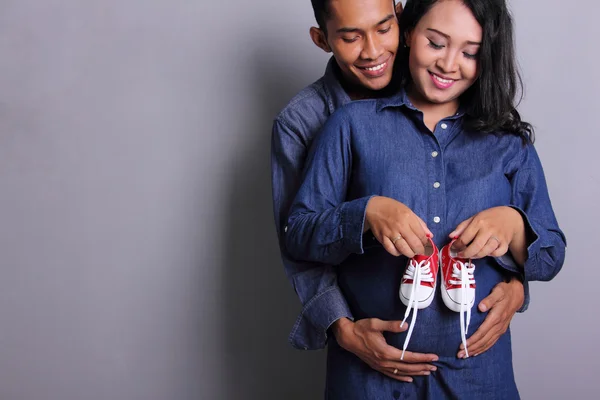 Happy ouders-to-be en baby schoenen — Stockfoto