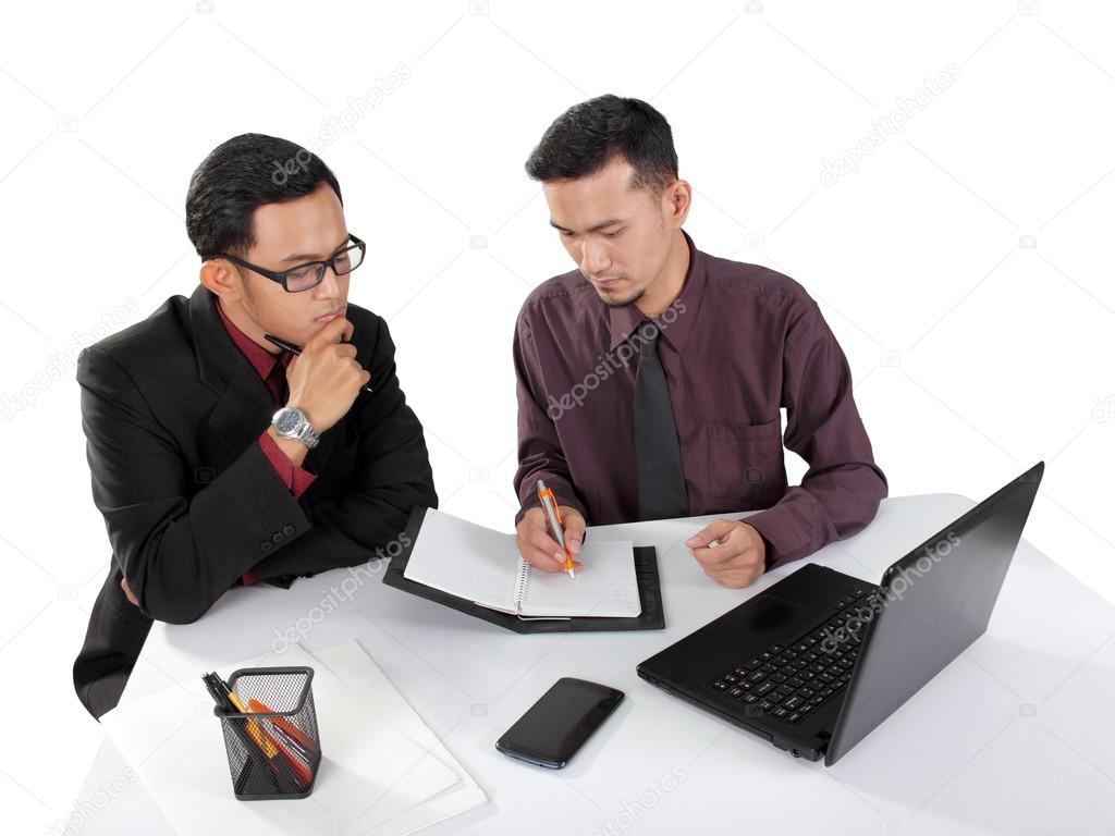 Businessman giving instructional note to his partner