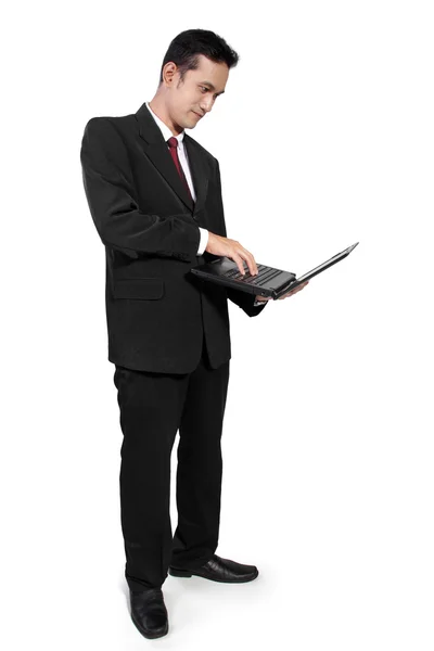 Affärsman stående användning laptop — Stockfoto