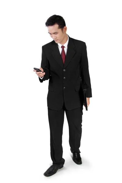 Uomo d'affari che cammina, controlla al telefono — Foto Stock