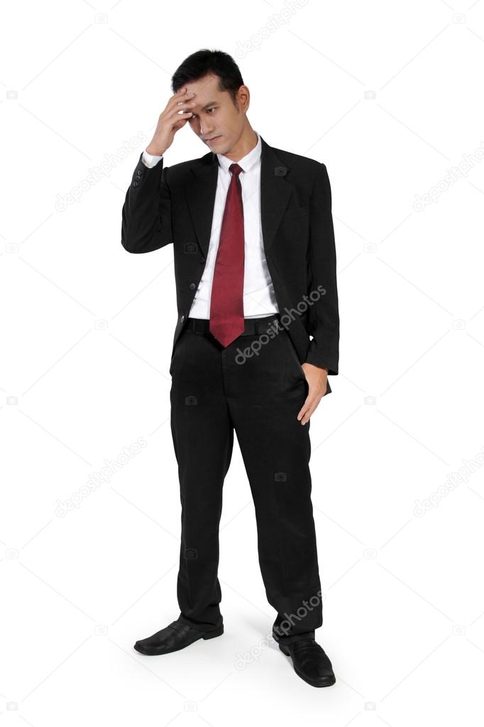 Standing businessman having headache