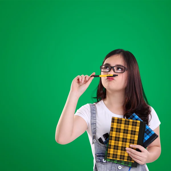 Schattig nerdy meisje kijk naar de top van groene achtergrond — Stockfoto