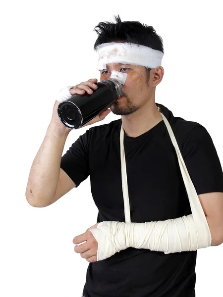 Hombre con el brazo roto bebiendo una botella de agua aislada — Foto de Stock