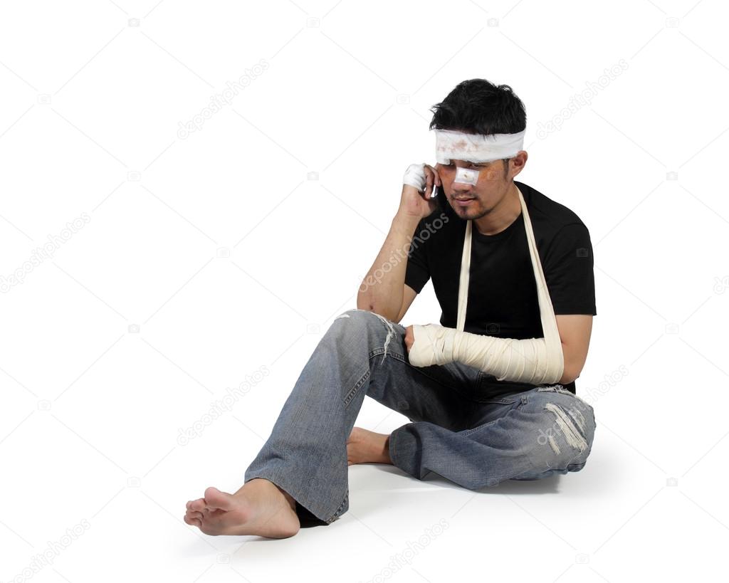 Injured man sits down and use cellphone