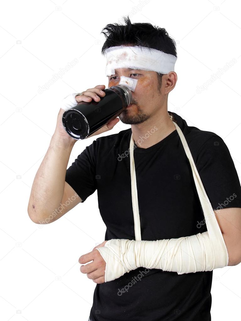 Man with broken arm drinking a bottle of water isolated