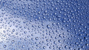 Bardaktaki su damlaları ışığı yansıtır ve titreşir.