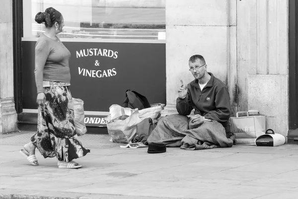 Бездомный разговаривает с прохожей — стоковое фото