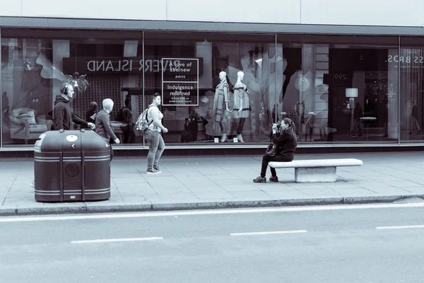 Fotógrafa callejera, mujer sentada tomar fotografías de personas caminando en Oxford Street en Londres, fotografía en blanco y negro, tonificación dividida — Foto de Stock