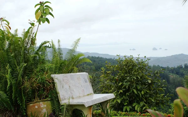 bench on top of a mountain with a sea view
