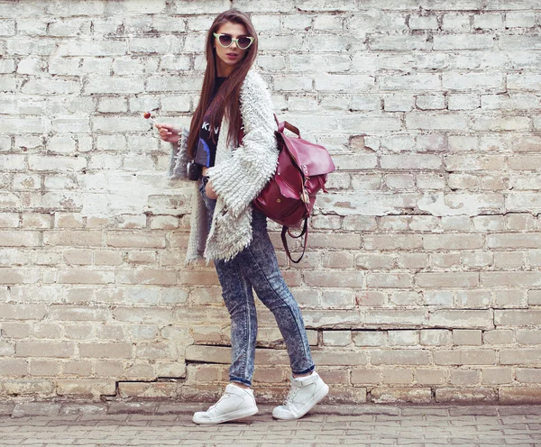 Młodych mody ulicznej dziewczyna na tle stary ceglany mur. na zewnątrz, styl życia. — Zdjęcie stockowe