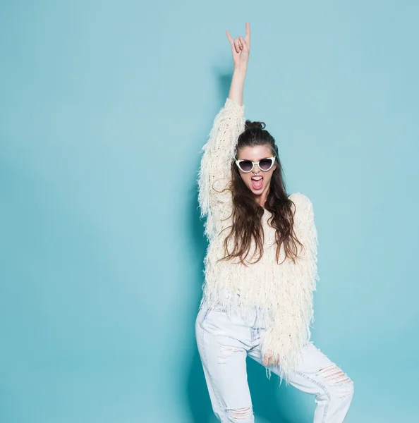 Porträt eines fröhlichen Mode-Hipster-Mädchens, das verrückt spielt, lustige Gesichter macht und tanzt. blauer Hintergrund. — Stockfoto