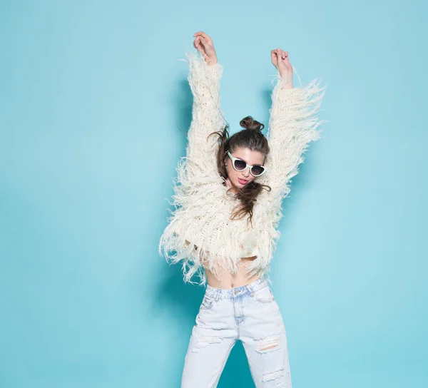 Retrato de moda alegre hipster chica volviéndose loco haciendo cara divertida y bailando. Fondo de color azul . —  Fotos de Stock