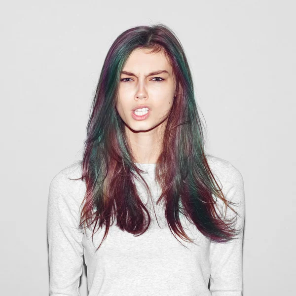 Gadis hipster emosional membuat eksperimen wajah lucu dengan rambut hijau warna pada latar belakang cahaya — Stok Foto