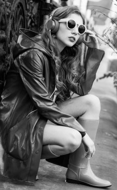 Parlak kıyafetli genç ve güzel bir kadın evde müziğin tadını çıkarıyor.