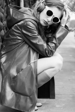 Parlak kıyafetli genç ve güzel bir kadın evde müziğin tadını çıkarıyor.