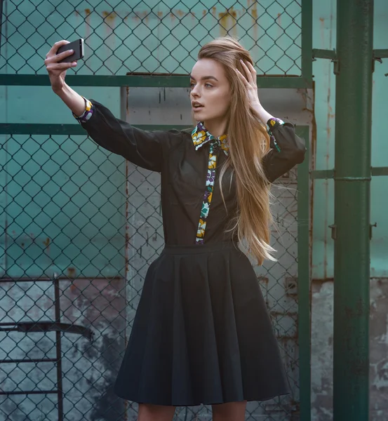 Retrato de una hermosa selfie mujer joven en el parque con un teléfono inteligente haciendo v signo — Foto de Stock