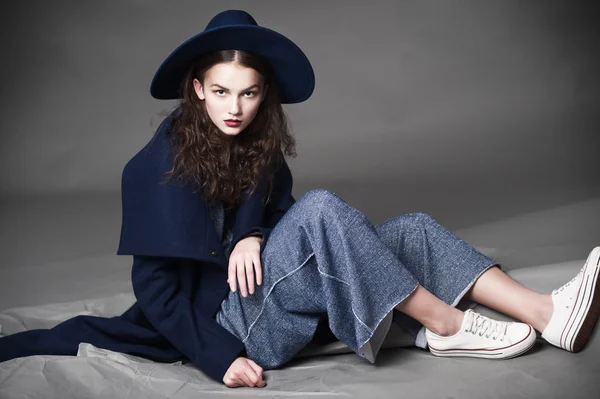 Moda modeli kadın palto ve şapka kentsel tarzı poz Studio renk arka plan üzerinde — Stok fotoğraf