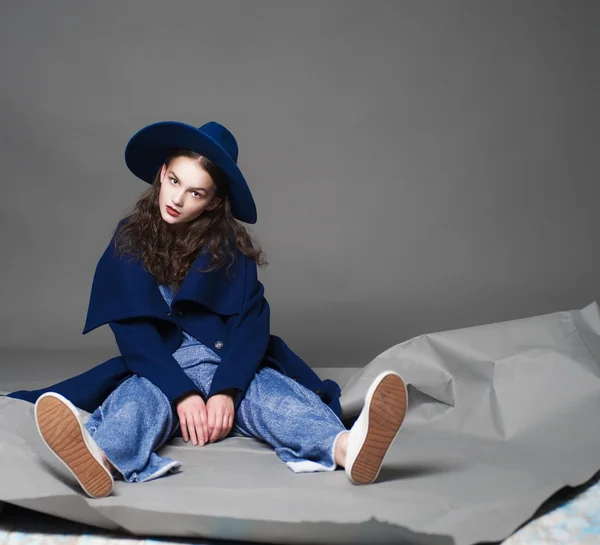 时尚模特女人外套和帽子城市风格造型在工作室中的颜色背景上 — 图库照片