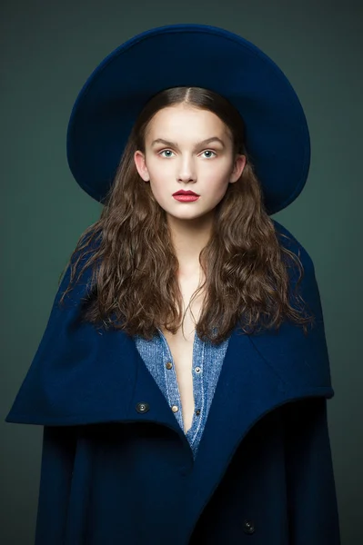 Modelo de moda mujer abrigo y sombrero estilo urbano pose sobre fondo de color en estudio —  Fotos de Stock