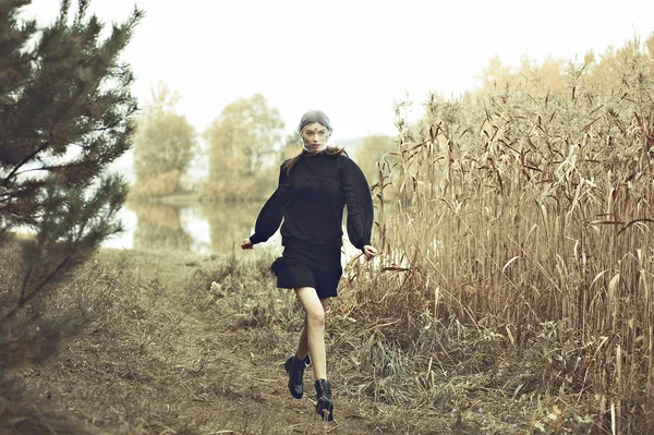 Modelo de moda mujer ejecutar en vestido negro. Fondo de naturaleza . — Foto de Stock