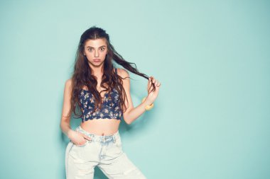 neşeli moda hippi kız deli komik surat yapma ve dans olacak portresi. Mavi renk arka plan.