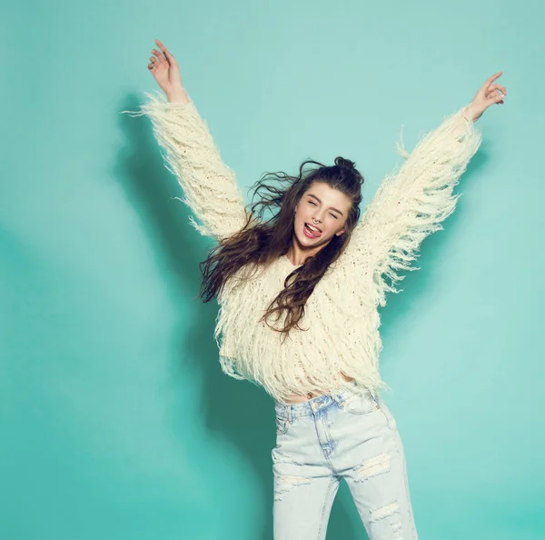 Portrait of cheerful fashion hipster girl going crazy making funny face and dancing. Blue color background. — Stock Photo, Image