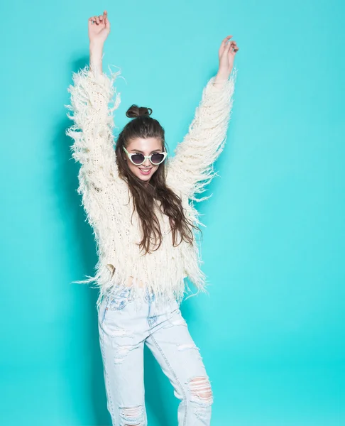 Portrait of cheerful fashion hipster girl going crazy making funny face and dancing. Blue color background. — Stock Photo, Image