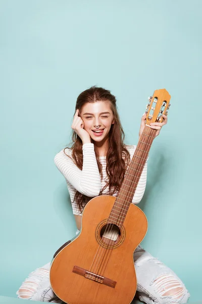 gülümseyen güzel genç kız gitarla poz