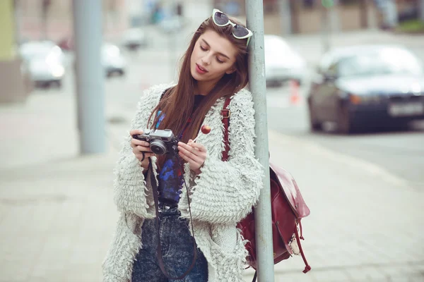 Femei de moda turist păstra camera compactă digitală și uita-te fotografie pe ecran. Ochelari de soare în stil Hipster și haină. Portret exterior — Fotografie, imagine de stoc