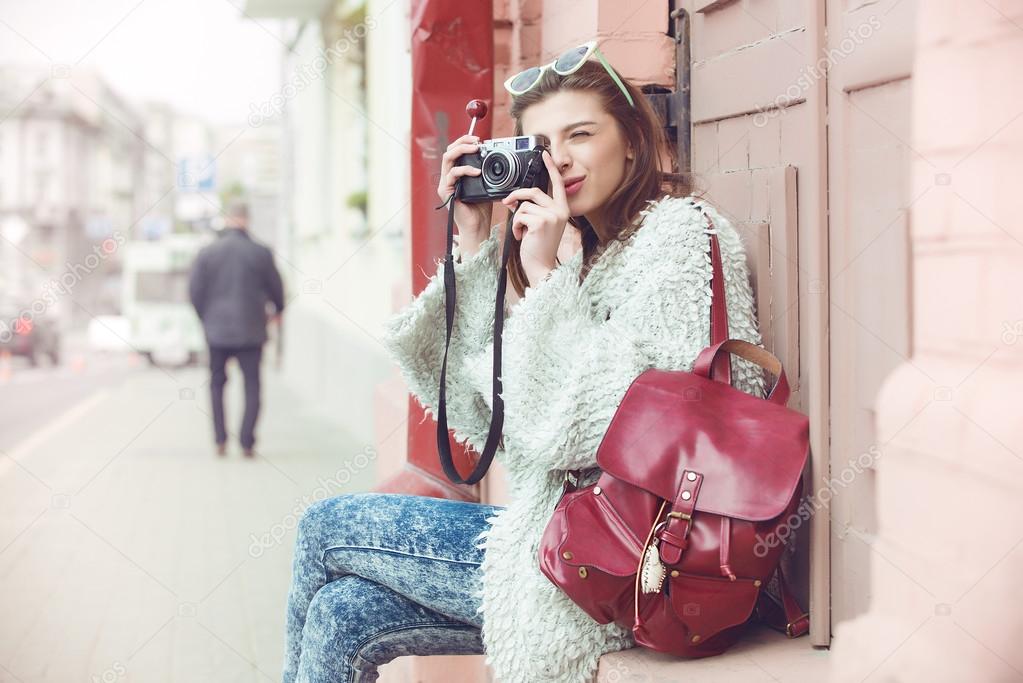 Fashion women tourist keep digital compact camera and look photo