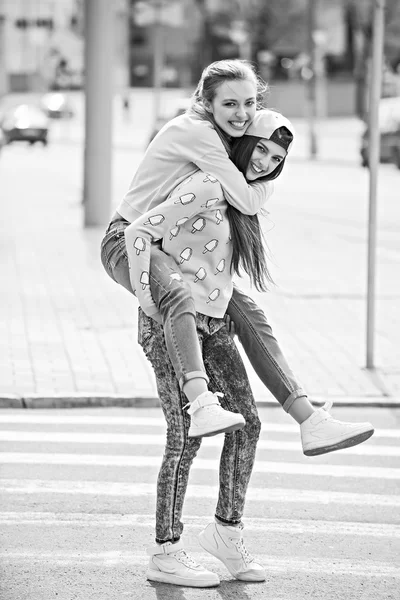 Modieuze mooie jonge vriendinnen permanent samen in de buurt van een blauwe achtergrond. Twee blondjes en een brunette. Gelet grappig en poseren. Binnen. Afgezwakt in warme kleuren — Stockfoto