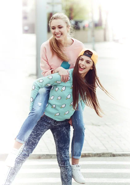 Moda hermosas novias jóvenes de pie juntos cerca de un fondo azul. Dos rubias y una morena. Divertirse y posar. En el interior. Tonificado en colores cálidos —  Fotos de Stock