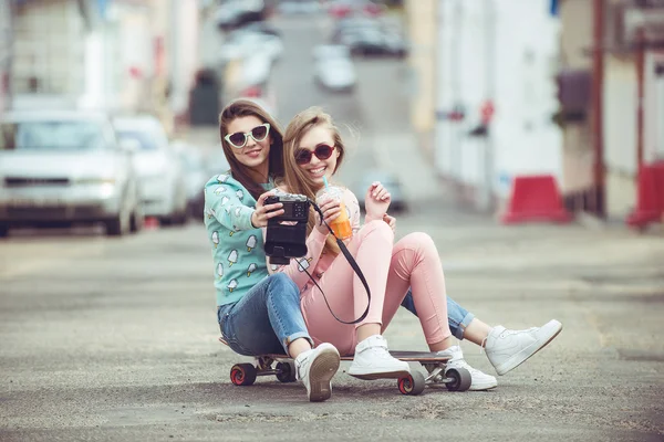 Hipster novias tomando una selfie en el contexto urbano de la ciudad - Concepto de amistad y diversión con nuevas tendencias y tecnología - Mejores amigos eternizando el momento con la cámara — Foto de Stock