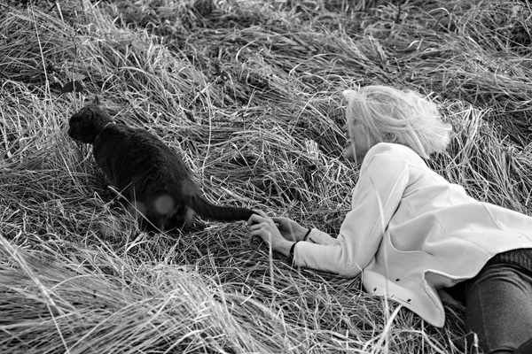 Jeune fille jouer avec un chaton dans l'herbe . — Photo