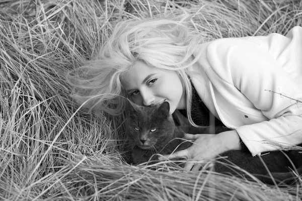 Giovane ragazza che gioca con un gattino nell'erba . — Foto Stock