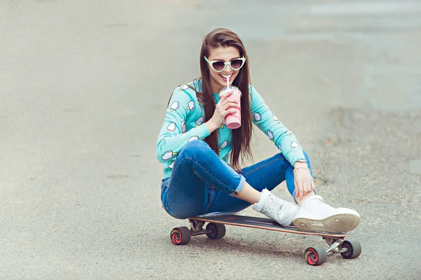 年轻漂亮的女人，和一个滑板，时尚的生活方式，在日落时的合影 — 图库照片