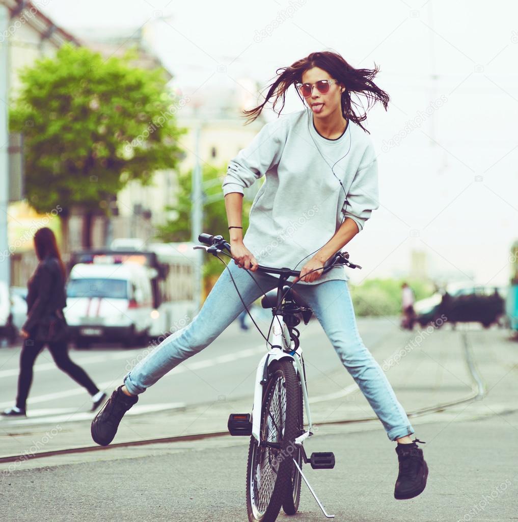 Colorful outdoor portrait of young pretty fashion model with bike. sexy woman posing in summer