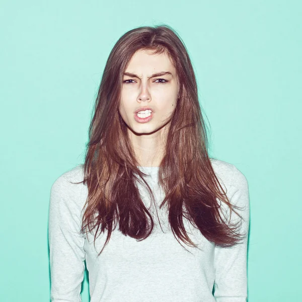 Emotional pretty young hipster girl make funny face on blue background — Stock Photo, Image