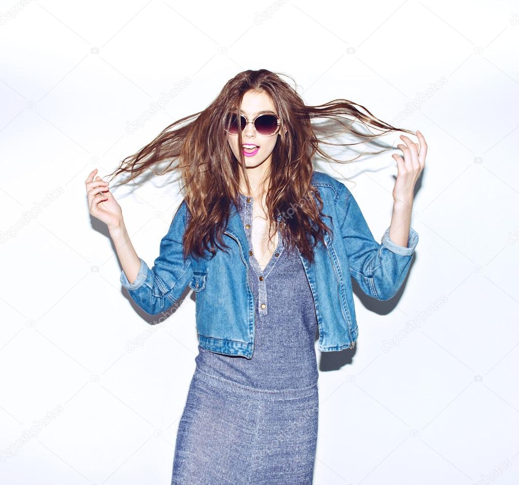 Emotional pretty young hipster girl make funny face on blue background