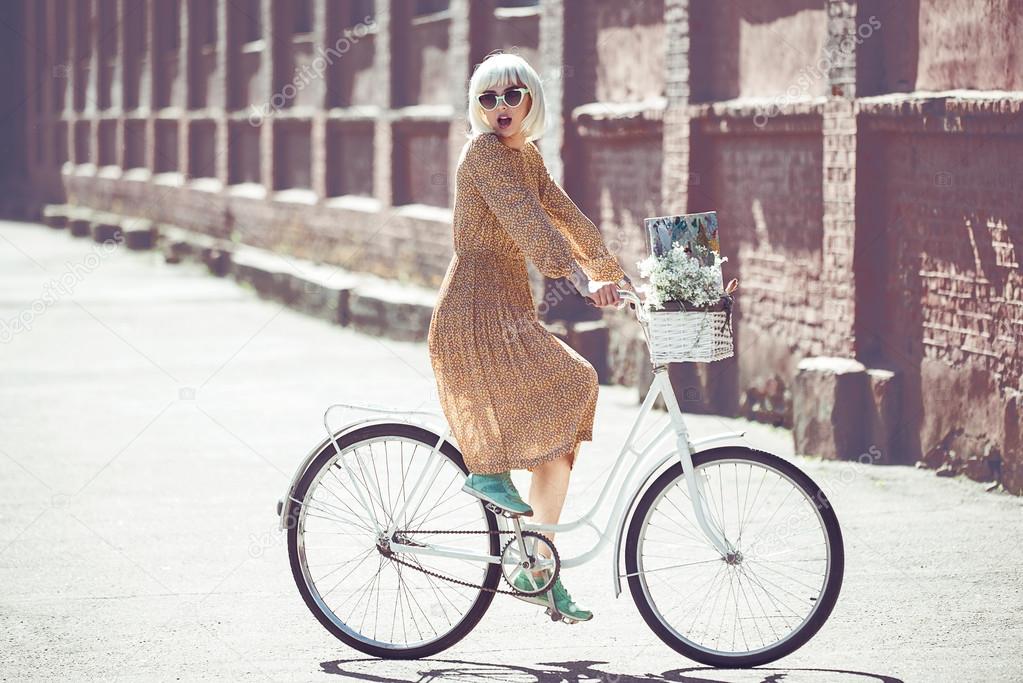 Hipster painter. Fashion blond woman with retro white bicycle street style outdoor portrait
