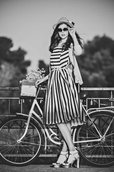 Молодая красивая элегантно одетая женщина с велосипедом. Красота, мода и образ жизни — стоковое фото