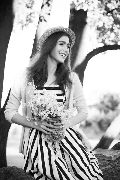Hipster mode meisje in stro hoed houden schoonheid bloemen — Stockfoto