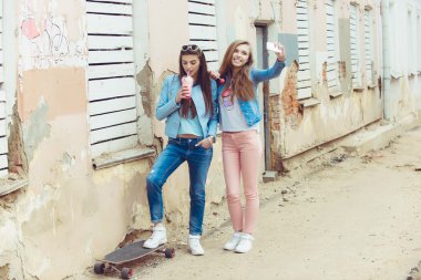 Güzel genç kızlar hippi kız poz bir paten kaykay koltukta, sokak moda yaşam tarzı güneş gözlüğü ile