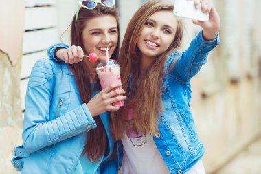 Hippi kız arkadaşlarım an modern smartphone ile eternalizing bir selfie - dostluk ve yeni trendler ve teknoloji ile eğlenceli kavramı - kentsel şehir bağlamda alarak