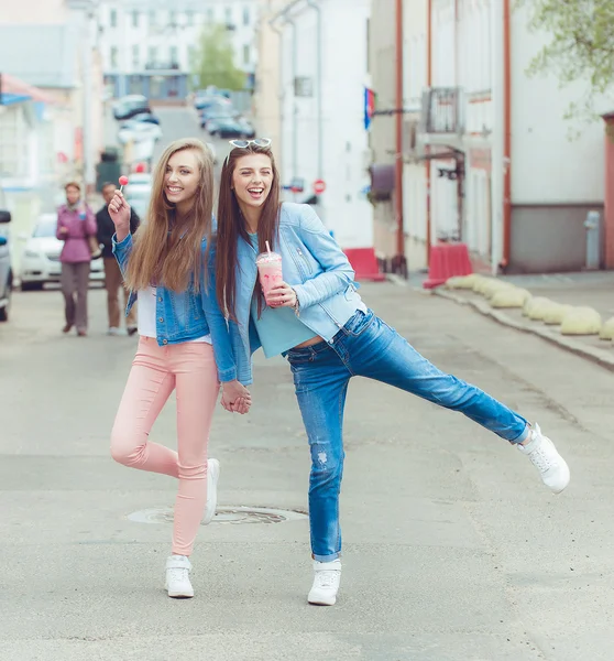 Beautiful young girls hipster girlfriends posing with a skateboard seat on skate, street fashion lifestyle in sunglasses — Stock Photo, Image